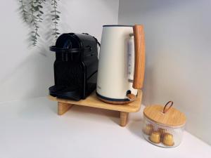 a coffee maker on a wooden stand next to a container at SEAESTA Cosy Sea Apartment in Koper