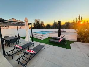 a patio with a table and chairs and a pool at Cantinho do Alandroal in Alandroal