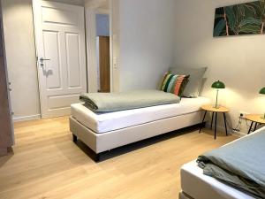 a bedroom with two beds and a white door at Ferienhaus Landliv Huus - mit Familienbett & Spielzimmer in Husby