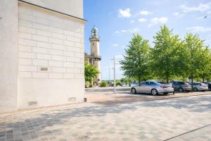 a car parked next to a building with a clock tower at Haus Wilbrand Ferienzimmer 2 in Warnemünde +3 photos