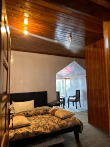 a bedroom with a bed and a desk and a chair at Kehkashan in Shongran
