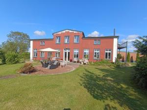a large red brick house with a large yard at Bauernhaus 3 -Vaest- in Fehmarn