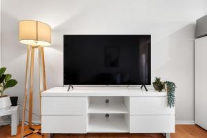 a white entertainment center with a flat screen tv on top at Sunny Side Studio - Mosman Park in Mosman Park