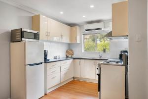 a kitchen with white appliances and a window at Sunny Side Studio - Mosman Park in Mosman Park