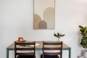 a table and two chairs in a room with a picture on the wall at Sunny Side Studio - Mosman Park in Mosman Park +7 photos