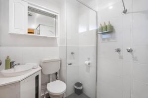 a white bathroom with a toilet and a shower at Sunny Side Studio - Mosman Park in Mosman Park