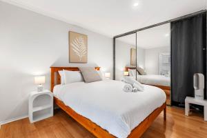 a bedroom with a large bed and a mirror at Sunny Side Studio - Mosman Park in Mosman Park