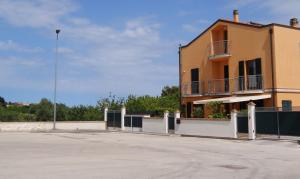 a building with a parking lot in front of it at Sirolo Summer Appartamento in Sirolo