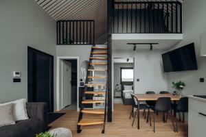 a living room and dining room with a spiral staircase in a tiny house at Cozy House Wisła - Domek z widokiem na góry in Wisła