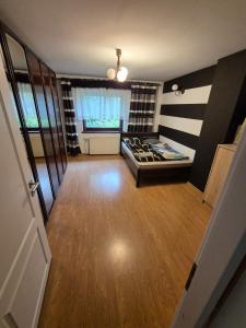 a large room with a bed and a wooden floor at Chillout Place in Wieprz