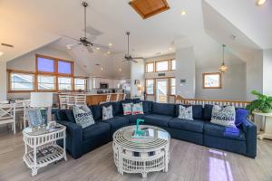 a living room with a blue couch and a table at On Island Time - KDH MP 7, 275 Yds to Beach, Pool, Hot Tub, Pool Table, Flex Stays in Kill Devil Hills