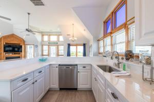 a large kitchen with white cabinets and a sink at On Island Time - KDH MP 7, 275 Yds to Beach, Pool, Hot Tub, Pool Table, Flex Stays in Kill Devil Hills +46 photos