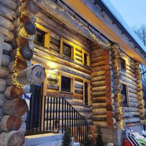 a log house with christmas lights on it at Villa Karhukumpu in Ivalo