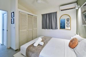 a bedroom with a bed with white sheets and a mirror at Villa Taleona in Santa Teresa Beach +55 photos