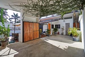 a house with a wooden door and some plants at Villa Taleona in Santa Teresa Beach