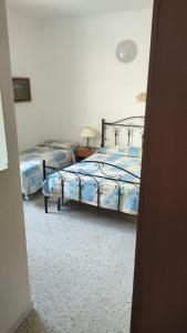 a bedroom with two beds and a table with a lamp at Borgo marino litorale salus in Sciacca