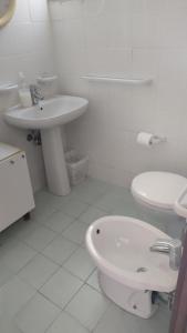 a white bathroom with a toilet and a sink at Borgo marino litorale salus in Sciacca