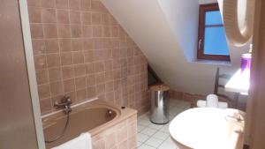 a bathroom with a sink and a bath tub at Chez Norbert gîte Le Riesling in Bergheim +7 photos