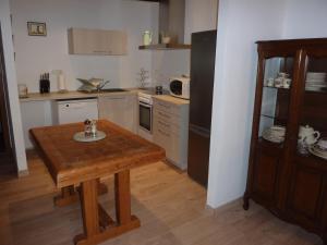 a small kitchen with a wooden table in a room at Chez Norbert gîte Le Riesling in Bergheim