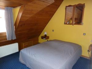 a bedroom with a white bed in a attic at Chez Norbert gîte Le Riesling in Bergheim