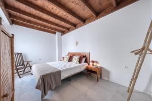 a bedroom with a bed and a wooden ceiling at Casa Eva in Famara