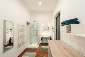 a white bathroom with a sink and a mirror at Apartments Paprikör in Tihany