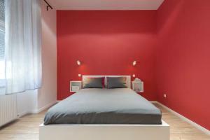 a bedroom with a red wall with a bed at Apartments Paprikör in Tihany +12 photos