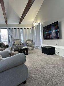 a living room with couches and a flat screen tv at Ottawa Family Nest in Ottawa