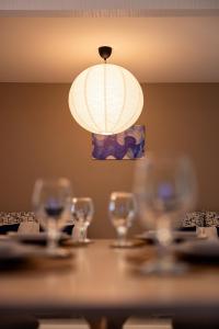 a table with wine glasses and a light fixture at BIEI BREEZE RESERVE Sui 水 in Biei