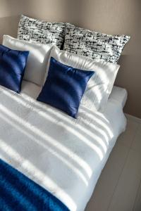 a white bed with blue pillows on top of it at BIEI BREEZE RESERVE Sui 水 in Biei