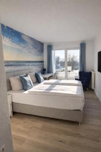 a bedroom with a large bed with a painting of the ocean at Hotel Deichgraf in Cuxhaven +29 photos