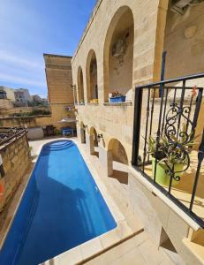 a swimming pool in a house with a balcony at Dotties Retreat Qala in Qala