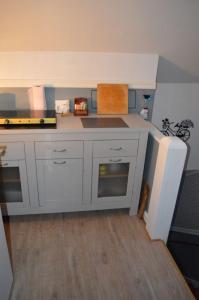 a kitchen with white cabinets and a cat sitting in the floor at Bodasjön II in Boda Glasbruk +8 photos