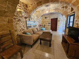 a living room with a couch and a tv at Dotties Retreat Qala in Qala