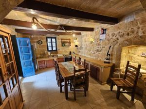 a kitchen with a table and chairs and a blue door at Dotties Retreat Qala in Qala +7 photos