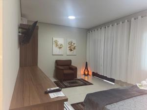 a living room with a couch and a chair at Pousada Avenida Farol in Campos dos Goytacazes