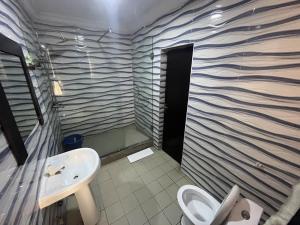 a bathroom with a sink and a toilet at Aotel Hotels & Suites - Ojota in Lagos