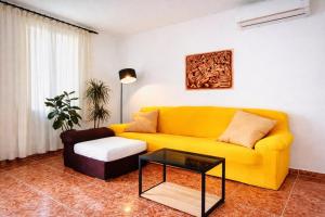a living room with a yellow couch and a coffee table at Manomar II, tu refugio en Gata in Gata