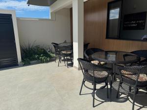 a patio with tables and chairs and a tv at Pousada Avenida Farol in Campos dos Goytacazes