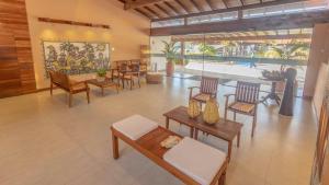 a living room with tables and chairs and a restaurant at Jardim Atlântico Beach Resort in Ilhéus