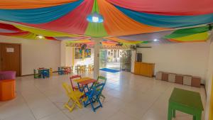 a room with colorful tables and chairs under a tent at Jardim Atlântico Beach Resort in Ilhéus