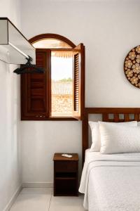 a bedroom with a bed and a window at Praia Jeri House in Jericoacoara