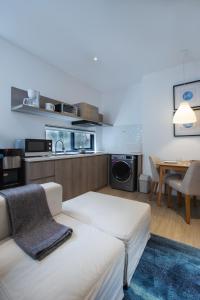 a living room with a couch and a kitchen with a table at Ariama Serviced Residence in Jakarta