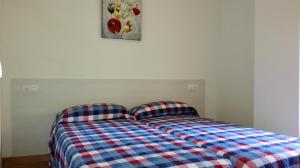 a bedroom with a bed with a plaid comforter at Apartamento Tosca Mar in Moraira +24 photos