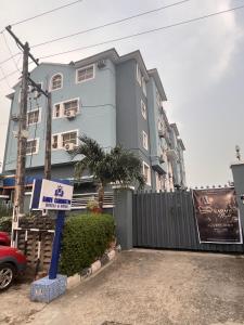 a blue building with a sign in front of it at Aotel Hotels & Suites - Ojota in Lagos +48 photos