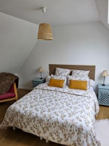 a bedroom with a large bed with yellow pillows at la guichardaye in Tréal
