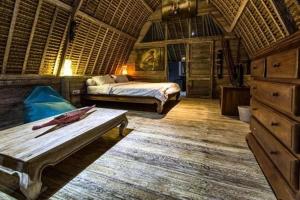 a bedroom with a bed and a table in a room at Gipsy Beach Bungalows in Sekotong