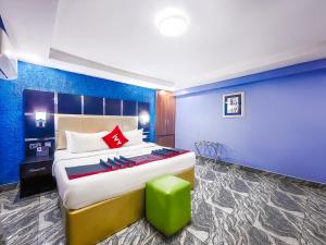 a bedroom with a large bed and a green stool at Aotel Hotels & Suites - Ojota in Lagos