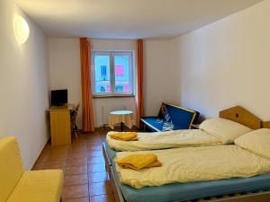 a bedroom with two beds and a window at Perla Valsole Hotel Ristorante in Acquarossa