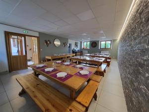 a dining room with wooden tables and a stone wall at La Marmotte De La Meije in Le Bourg-dʼOisans +34 photos